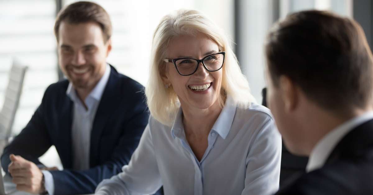 Woman leader with glasses smiling at colleague