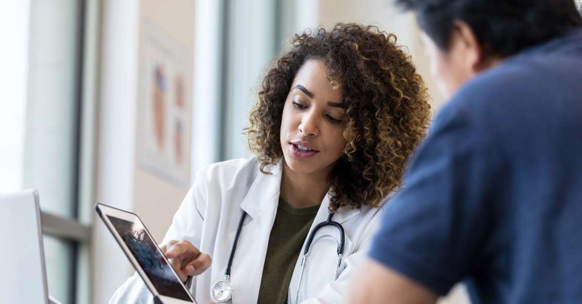 Female doctor discussing something on tablet with nurse